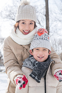年轻妈妈带着孩子在雪地玩耍图片