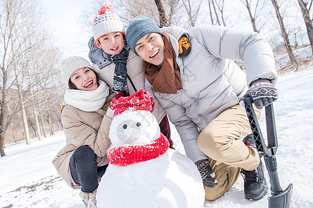 一家三口在雪地里堆雪人图片