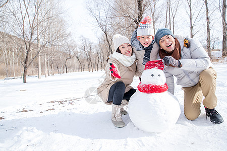 一家三口在雪地里堆雪人图片