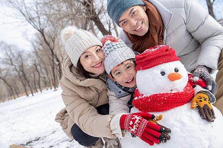 一家三口在雪地里堆雪人图片