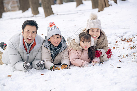 趴在雪地里玩耍的快乐家庭图片