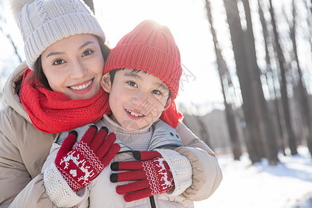 年轻妈妈带着孩子在雪地玩耍图片