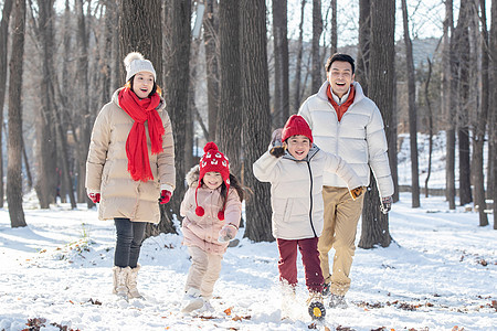 欢乐家庭在雪地里奔跑图片