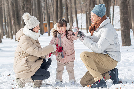 一家三口在雪地里玩耍图片