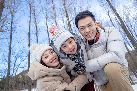 在雪地上玩耍的一家三口图片