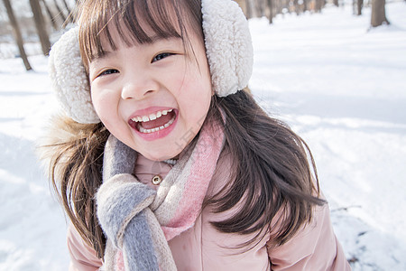 快乐的小女孩在雪地里玩耍图片