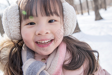 快乐的小女孩在雪地里玩耍图片