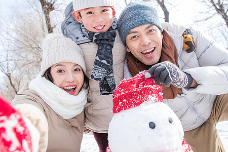 一家三口在雪地里堆雪人图片