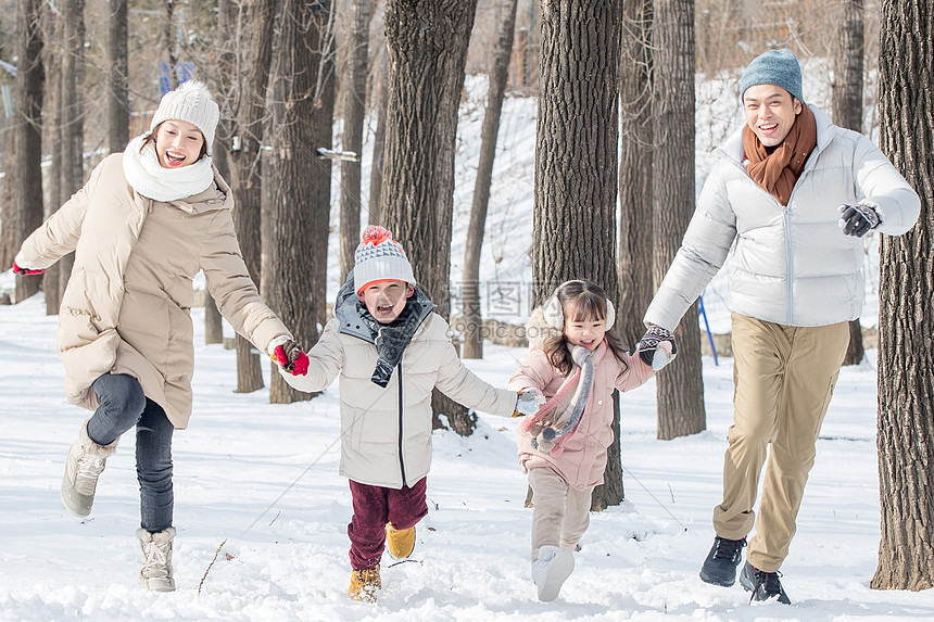 欢乐家庭在雪地里奔跑图片