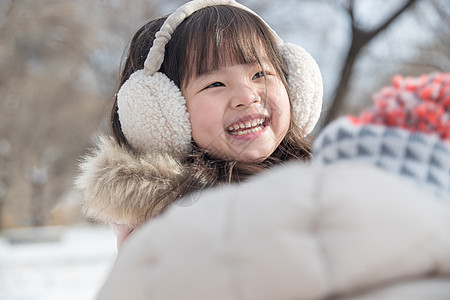 快乐的小女孩在雪地里玩耍图片