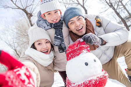 一家三口在雪地里堆雪人图片