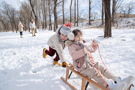 欢乐家庭在雪地上玩雪橇图片