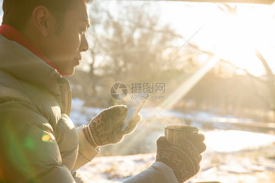 坐在雪地里看手机的男人图片