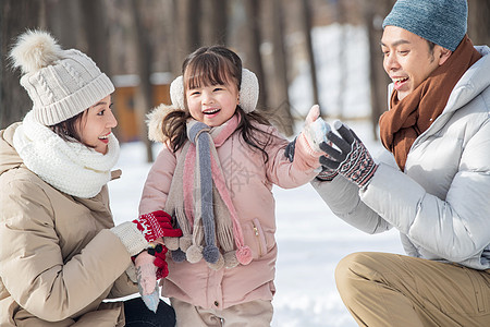 一家三口在雪地里玩耍图片