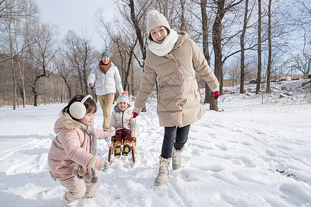 欢乐家庭在雪地上玩雪橇图片