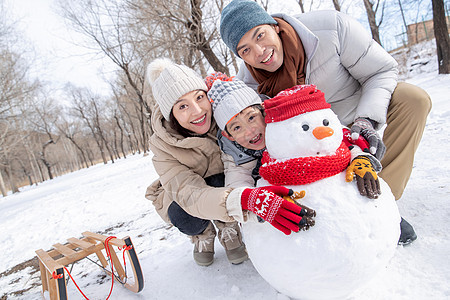 一家三口在雪地里堆雪人图片