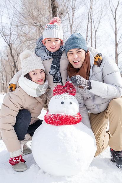 一家三口在雪地里堆雪人图片