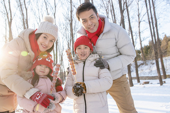 雪地里拿着糖葫芦的快乐家庭图片