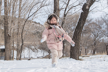 快乐的小女孩在雪地里玩耍图片