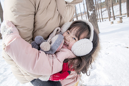 快乐的小女孩在雪地玩耍图片