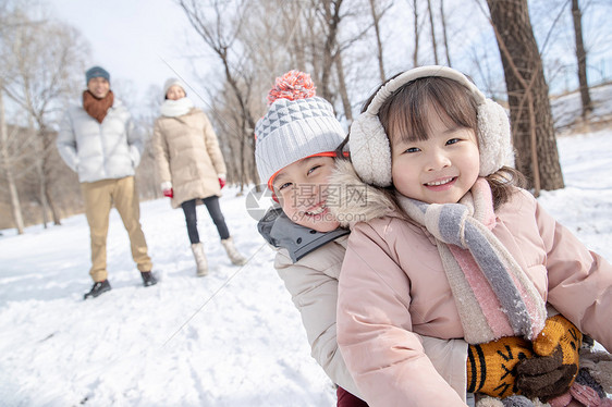 欢乐家庭在雪地上玩雪橇图片