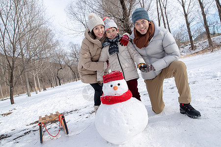 一家三口在雪地里堆雪人图片