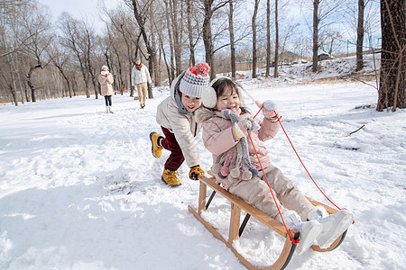 欢乐家庭在雪地上玩雪橇图片