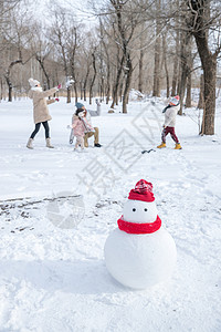 新年衣服雪地里的一家人和雪人背景