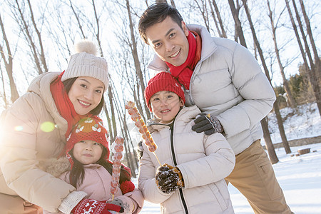 雪地里拿着糖葫芦的快乐家庭图片