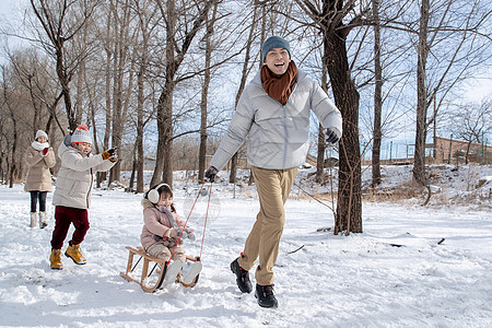 欢乐家庭在雪地上玩雪橇图片