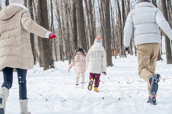 欢乐家庭在雪地里奔跑图片