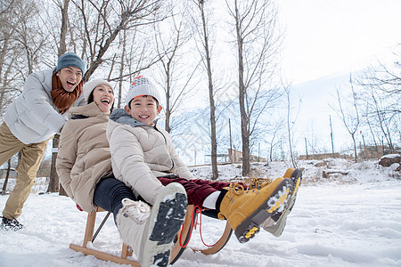 推着雪橇玩耍的一家人图片