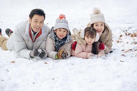 趴在雪地里玩耍的快乐家庭图片