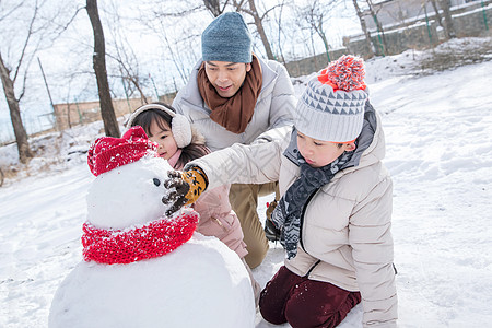 爸爸和孩子们推雪人图片