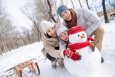 一家三口在雪地里堆雪人图片