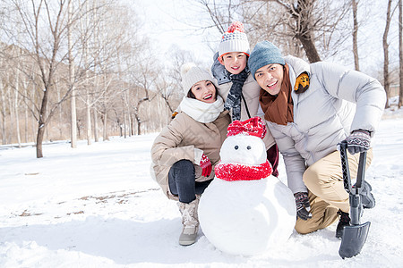 一家三口在雪地里堆雪人图片