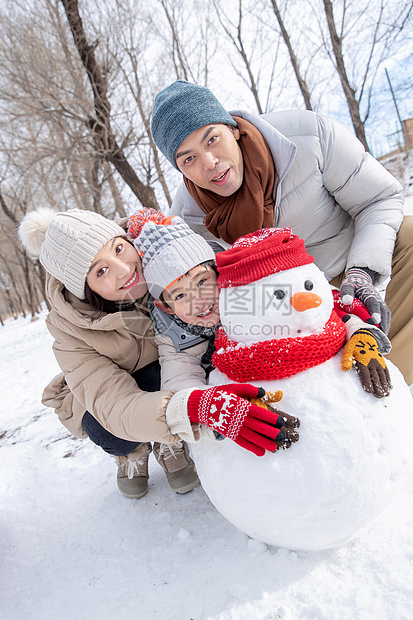 一家三口在雪地里堆雪人图片