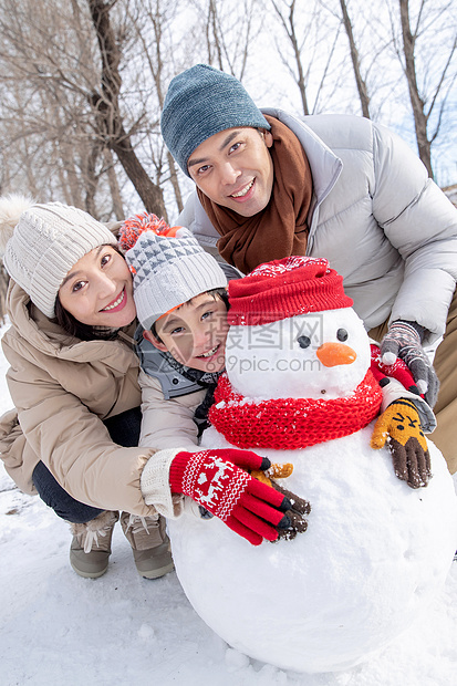 一家三口在雪地里堆雪人图片