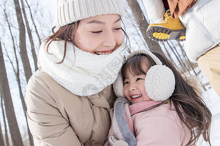 年轻啊妈妈和女儿在雪地里玩耍图片