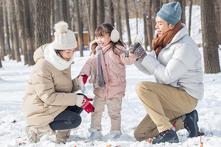 一家三口在雪地里玩耍图片