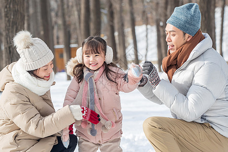 一家三口在雪地里玩耍图片