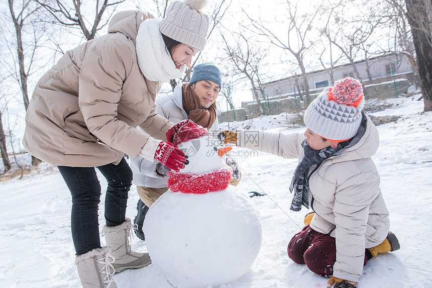 一家三口在雪地里堆雪人图片