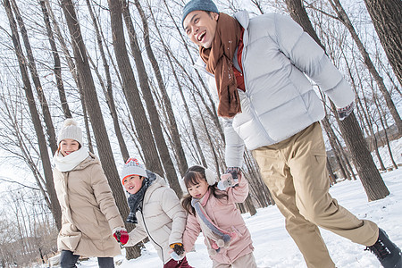 欢乐家庭在雪地里奔跑图片