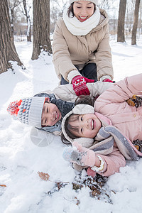 年轻妈妈和孩子们在雪地里玩耍图片