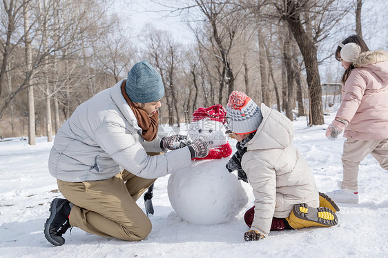 爸爸和孩子们推雪人图片