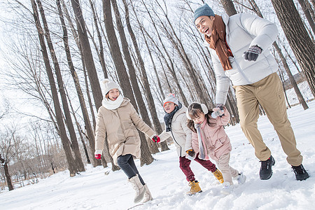 欢乐家庭在雪地里奔跑图片