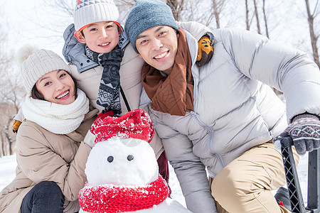 一家三口在雪地里堆雪人图片