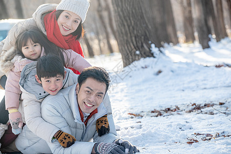 趴在雪地里玩耍的快乐家庭图片