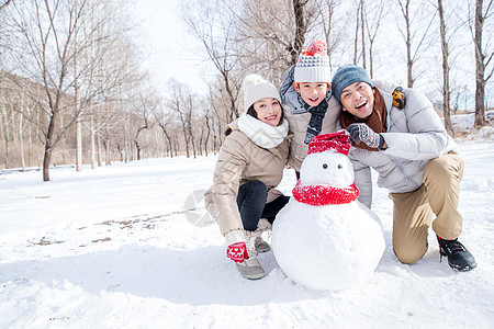 一家三口在雪地里堆雪人图片