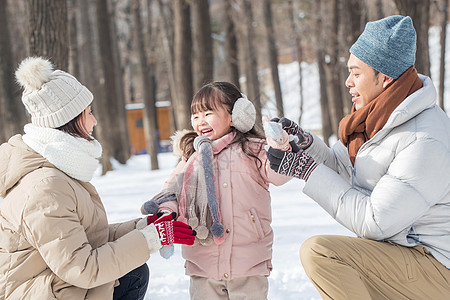 一家三口在雪地里玩耍图片